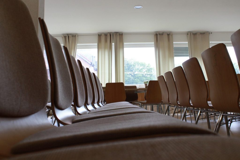 Rangées de chaises vides dans une salle de séminaire lumineuse, illustrant une salle de formation à Tours