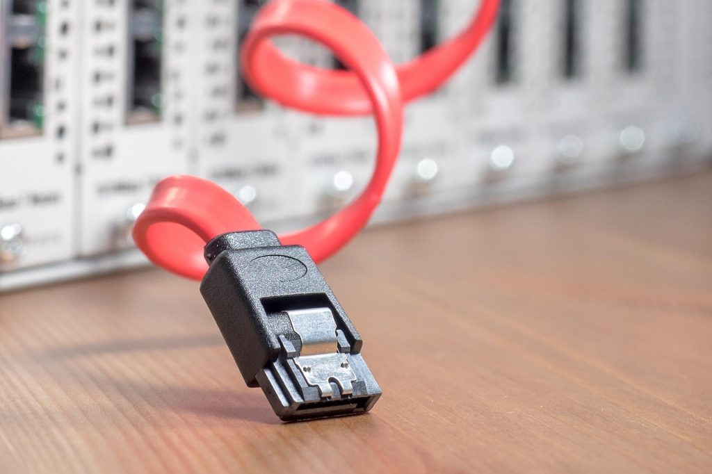 Câble de données rouge posé devant une baie de serveurs, illustrant la connexion entre Odoo et une IA via MCP
