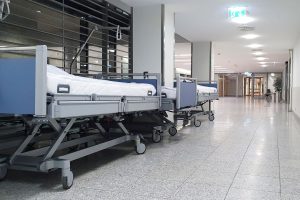 Lits d'hôpital alignés dans un couloir, symbole de la gestion des lits dans les parcours de soins complexes