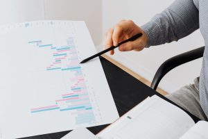 Main pointant au stylo un graphique imprimé, illustrant l'analyse des données d'Odoo par une IA via MCP