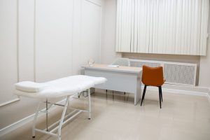 Salle de consultation claire et moderne, avec bureau et table d'examen, dans un établissement de soins