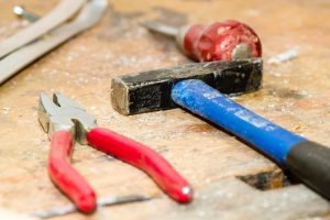Marteau, pinces et tournevis sur un établi, les outils de la maintenance d'une application Symfony