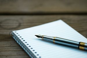 Stylo plume posé sur un carnet à spirale, illustrant la préparation d'un parcours de formation