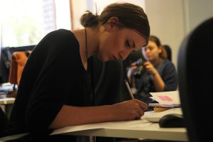Personne annotant attentivement un document à son bureau, illustrant la revue humaine du code